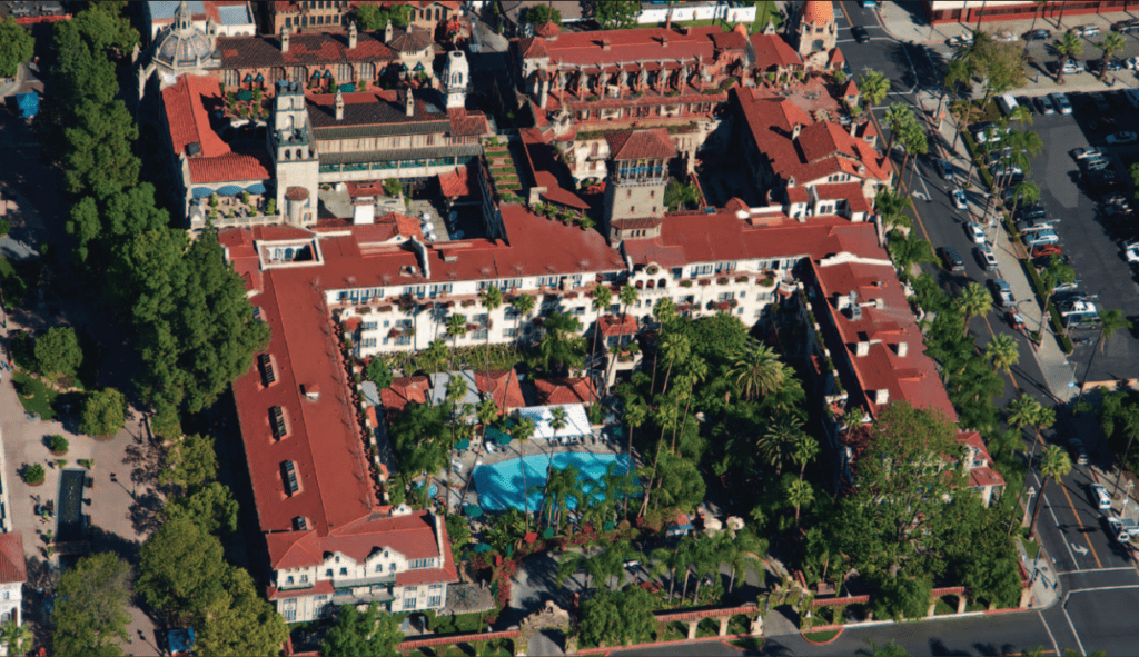 Aerial view of the Mission Inn showing its complex layout of red-tiled wings and courtyards occupying an entire city block